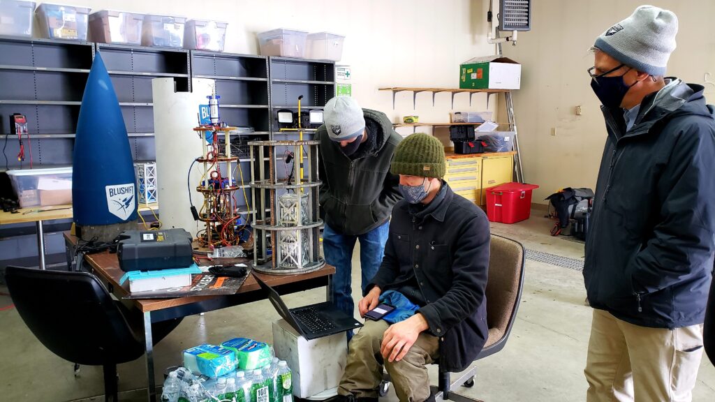 team observing rocket tech close up in lab